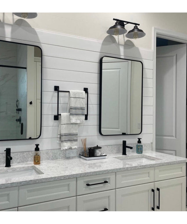 Black metal Parker Hand Towel Holder ladder mounted on white shiplap bathroom wall between two mirrors with folded towels ...