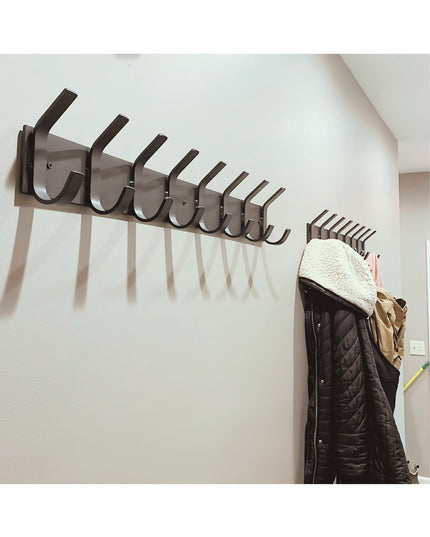 Metal Coat Rack System Black wall-mounted metal coat rack with multiple hooks displaying ...