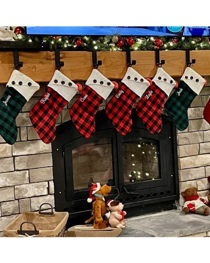 Black metal Annie Stocking Holder from Industrial Farm Co displaying six plaid Christmas stockings on rustic stone firepla...