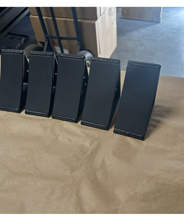 Five black metal Eleanor 5x5 Brackets by Industrial Farm Co arranged in a row on wooden surface, showing welded steel cons...