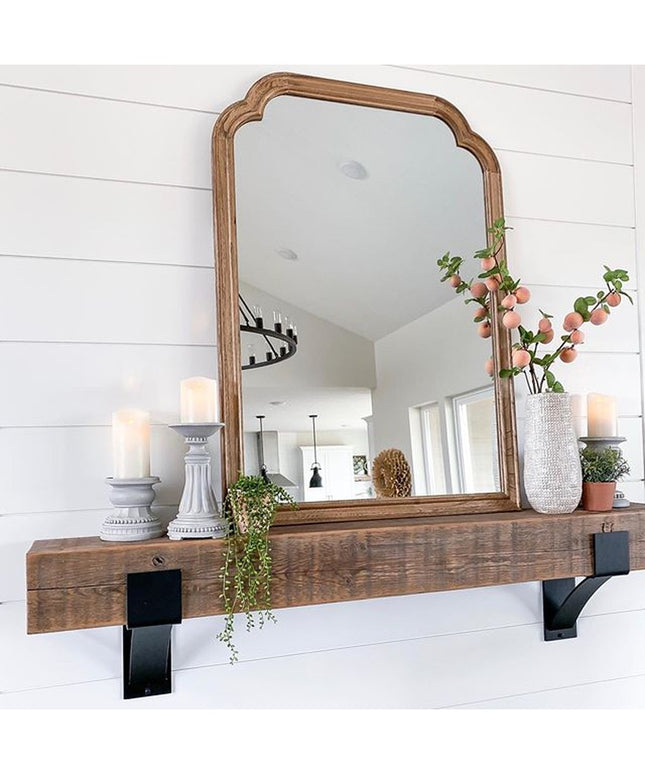 Kudlick Farmhouse wooden mantel shelf with black metal brackets mounted on white shiplap wall, decorated with mirror, cand...