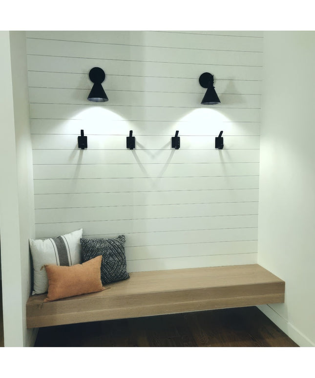 Black metal Elizabeth Wall Hooks by Industrial Farm Co mounted on white shiplap wall above wooden bench with pillows and s...