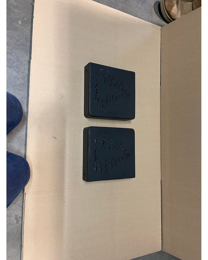 Two dark green Vandiver Evergreen Tree Mantel End Caps with embossed pine tree designs displayed on beige cardboard by Ind...