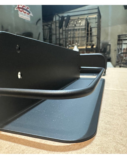 Herdon matte black metal wall-mounted shelf with curved design on wooden table in Industrial Farm Co workshop setting