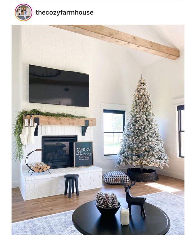 Living room with Christmas tree, fireplace, and TV in a cozy farmhouse setting.