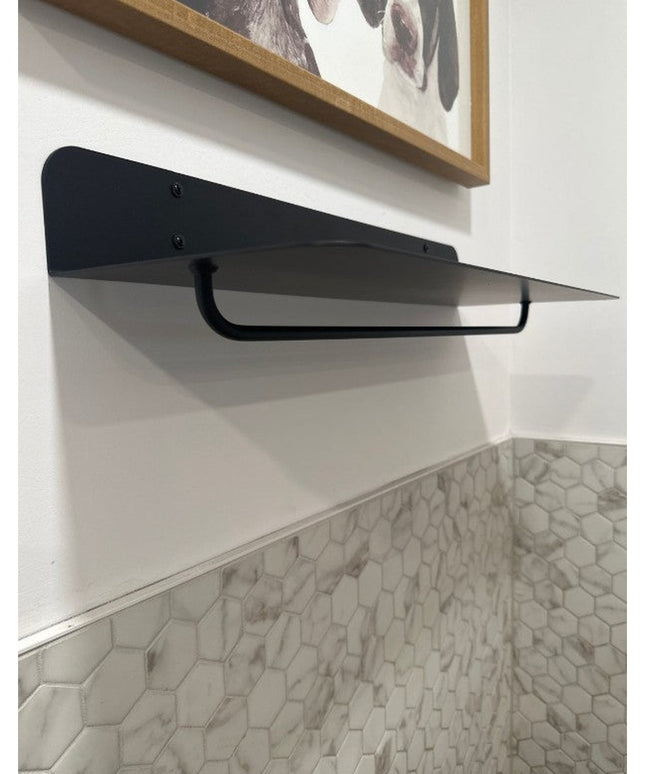 Black metal Houston wall shelf with triangular design mounted on white wall above marble hexagon tile backsplash by Indust...