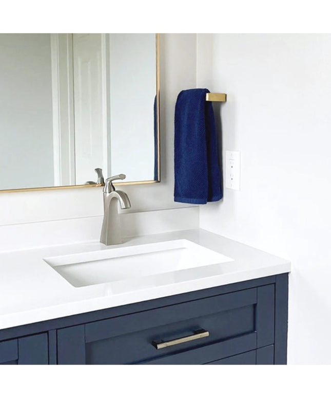 Modern bathroom vanity featuring navy blue cabinets with brass Emma Towel Holder by Industrial Farm Co, white countertop a...