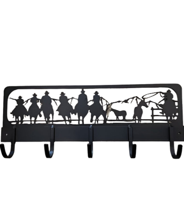 Black metal Western Charm coat rack featuring silhouette cutout of cowboys on horseback with mountains, 5 wall-mounted hoo...
