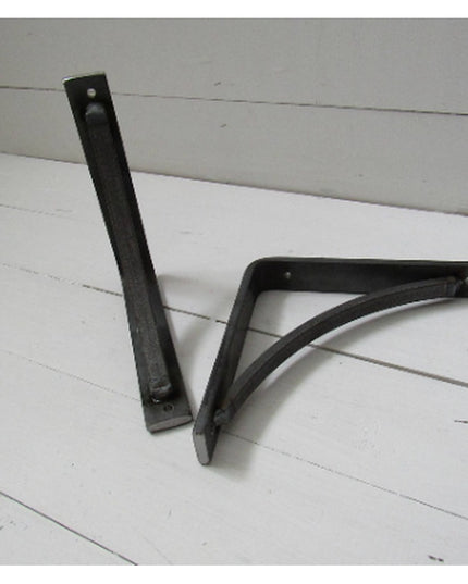 Heavy duty black steel Oak Hill industrial shelf brackets with curved support bars by Industrial Farm Co on white wood bac...