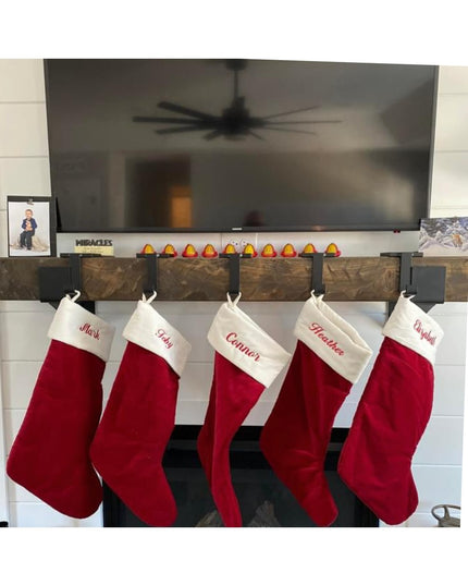 Red and white Christmas stockings hanging from Industrial Farm Co Annie Stocking Holder mounted on white brick fireplace m...