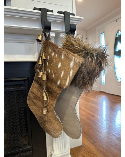 Black metal Annie Stocking Holder by Industrial Farm Co hanging two Christmas stockings with fur trim on white fireplace m...