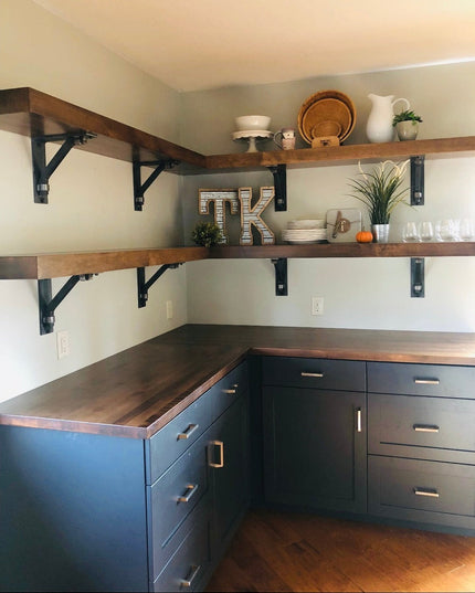 Black metal Butch Shelf Supports by Industrial Farm Co holding rustic wood shelves in modern farmhouse kitchen with navy c...