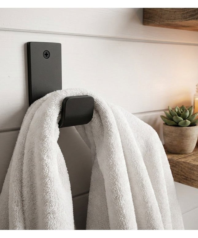 Black metal Western Ridge 1.5" J Wall Hook by Industrial Farm Co mounted on white shiplap wall holding white towel with ca...