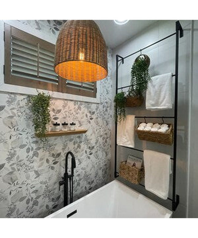 Black metal Veronica Modern Blanket Ladder by Industrial Farm Co displayed in spa bathroom with wicker baskets and towels