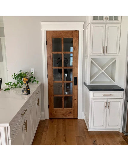 Black Lockport Pull door handle by Industrial Farm Co on natural wood pantry door with glass panels in white kitchen