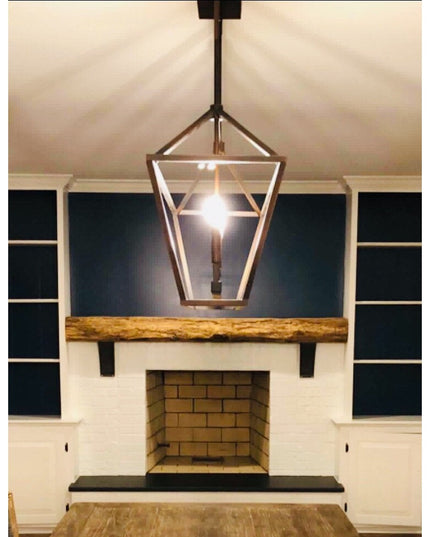 Black metal Tipp Hill Mantel Support brackets holding rustic wood beam above white fireplace with built-in shelving by Ind...