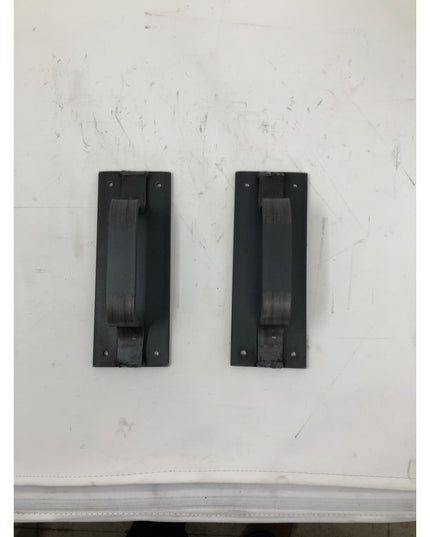 Two black metal Lockport Pull door handles mounted on white wall, featuring rectangular backplates with vertical pull bars...